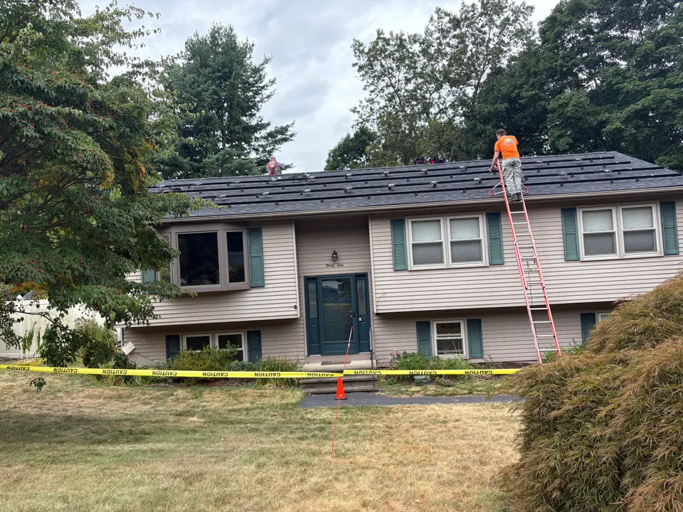 Solar installation crew setting roof racking on a residential home